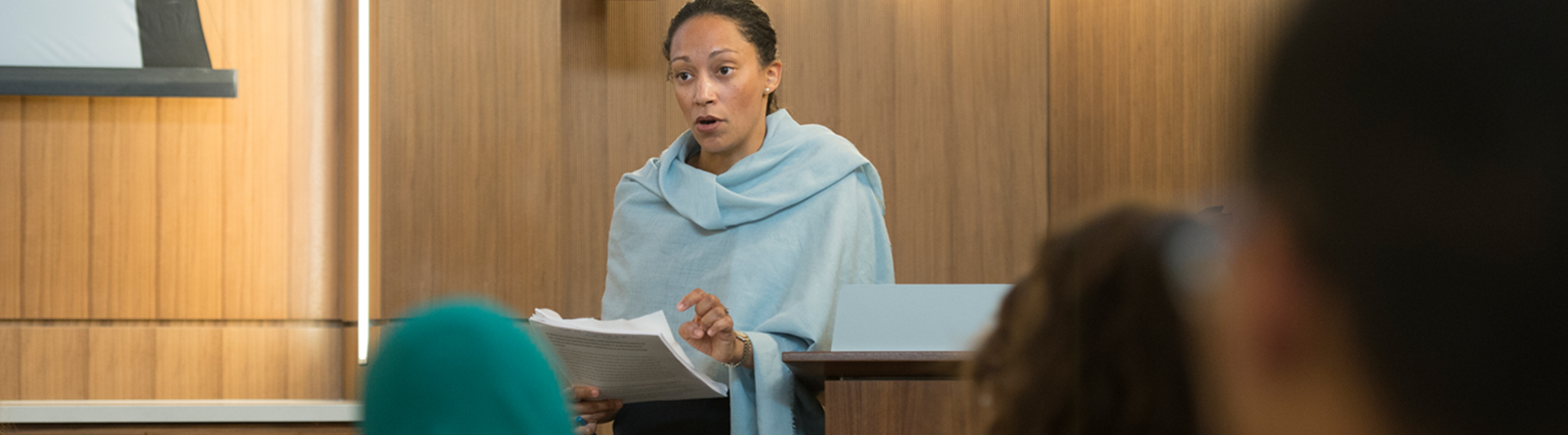 Woman giving speech to group in president's room