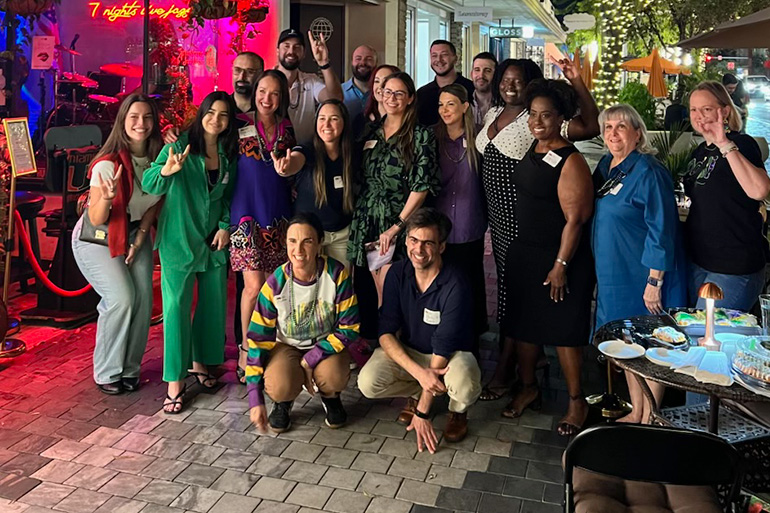 Alumni gather for a photo at a 2025 Mardi Gras Meet Up